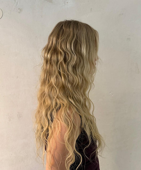 Langes, gewelltes blondes Haar von der Seite