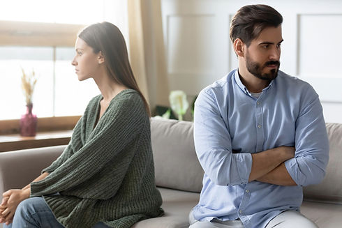 Ein Paar sitzt mit Abstand und abgewandtem Blick nebeneinander auf dem Sofa – eine typische Ausgangssituation, wenn Kommunikation schwierig wird. Das Bild symbolisiert Herausforderungen, bei denen die Eheberatung Wien Paare wieder ins Gespräch bringt.