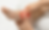 Eine Person hält den Fuß und drückt mit beiden Händen auf den schmerzhaften Bereich an der Ferse/Innenseite, der rot markiert ist. Das Bild visualisiert typische Fußschmerzen beim Auftreten oder nach Belastung.
