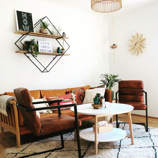 Gemütlich eingerichteter Praxisraum von Christian Asperger, Spezialist für Paartherapie, Paarberatung und Eheberatung in Wien. Das stilvolle Ambiente mit warmen Farben, Pflanzen und persönlicher Note schafft eine vertrauensvolle Atmosphäre für offene Gespräche und persönliche Entwicklung.