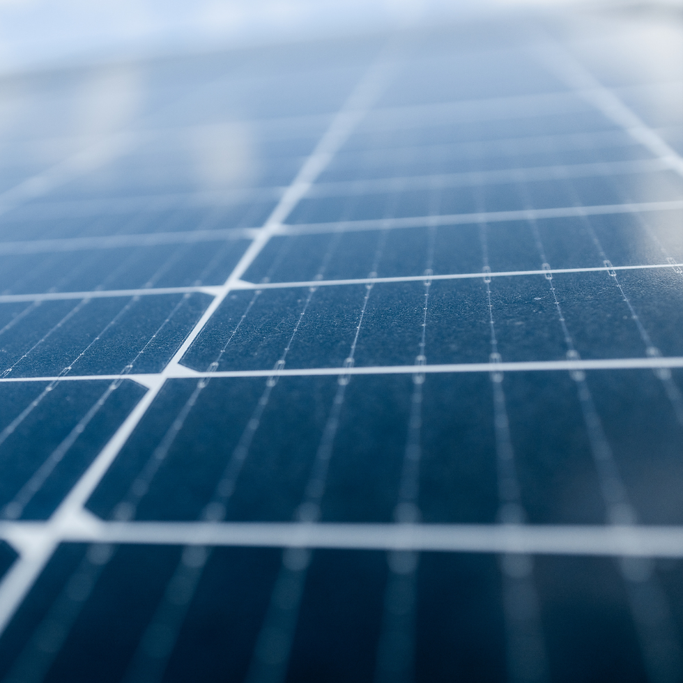 Close-up of a blue solar panel with visible grid lines under soft light, displaying a clean, modern, and energy-efficient warehouse setting.
