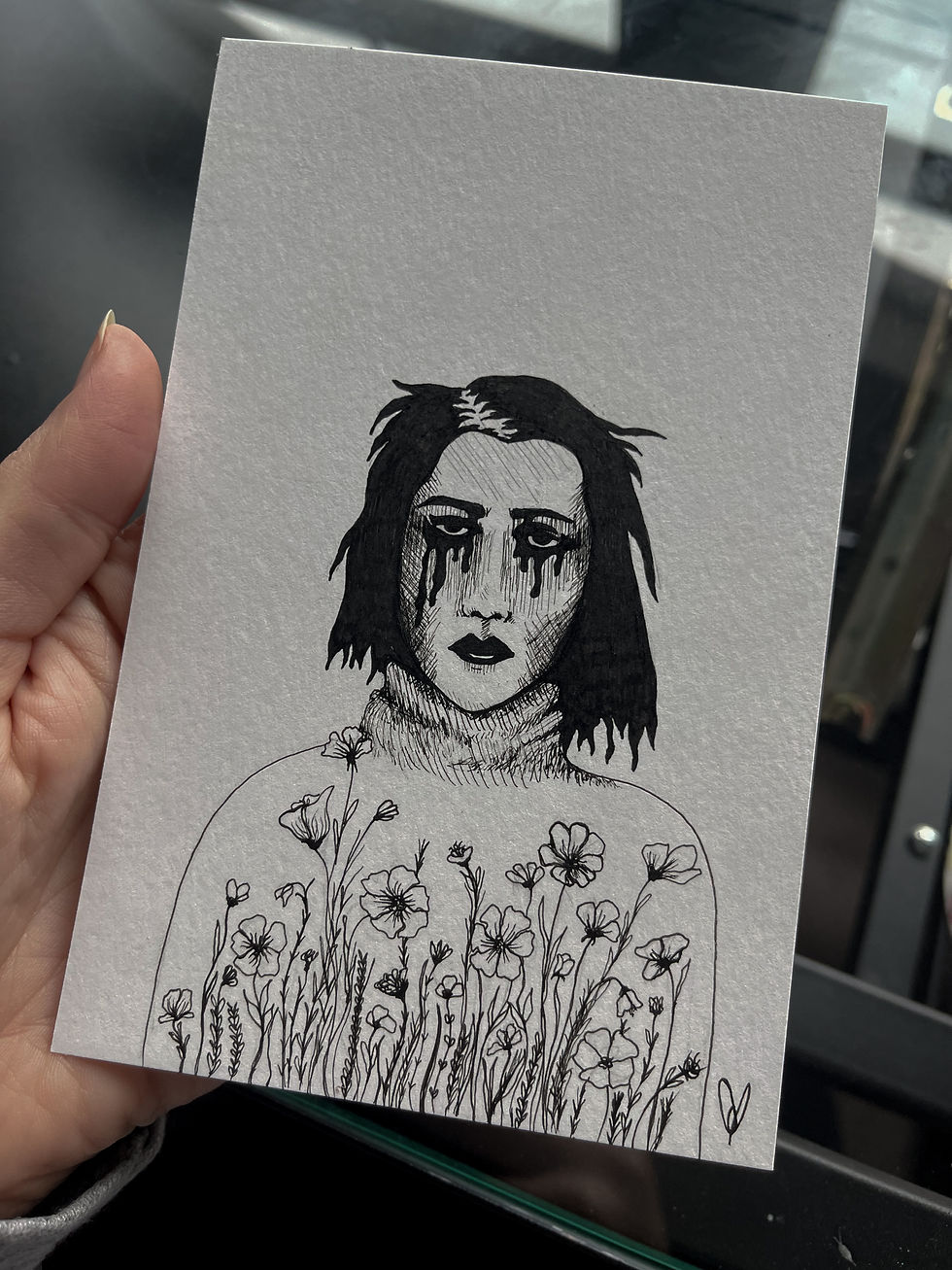 Black and white ink drawing of a person with shoulder-length messy hair and flowers.
