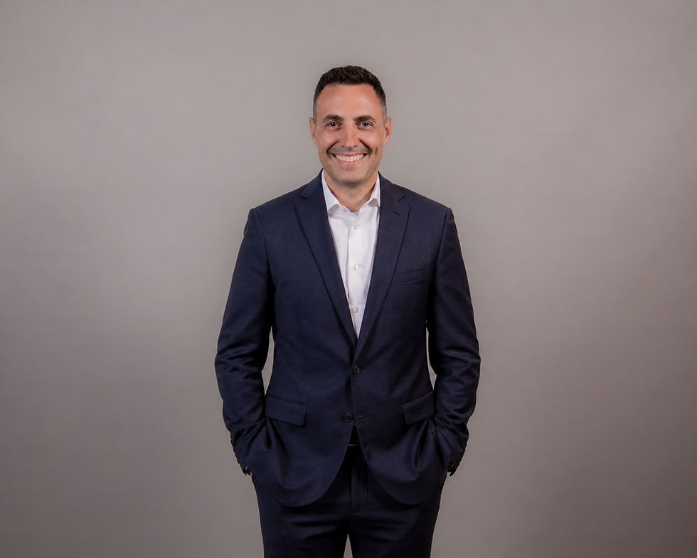 Smiling man in a navy suit with hands in pockets
