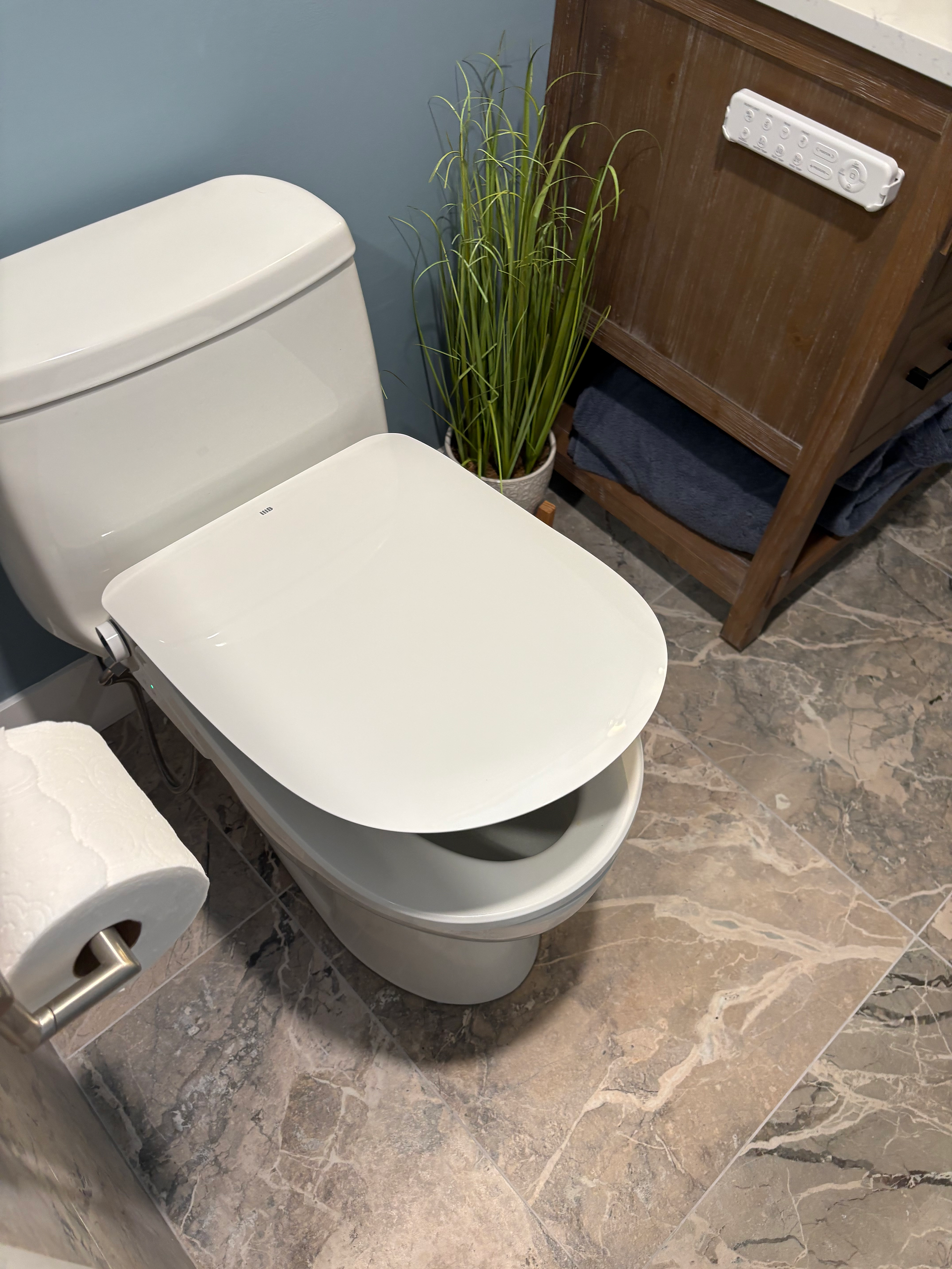 Heated Bidet Seat with Remote Control in Holder on Side of Vanity 
