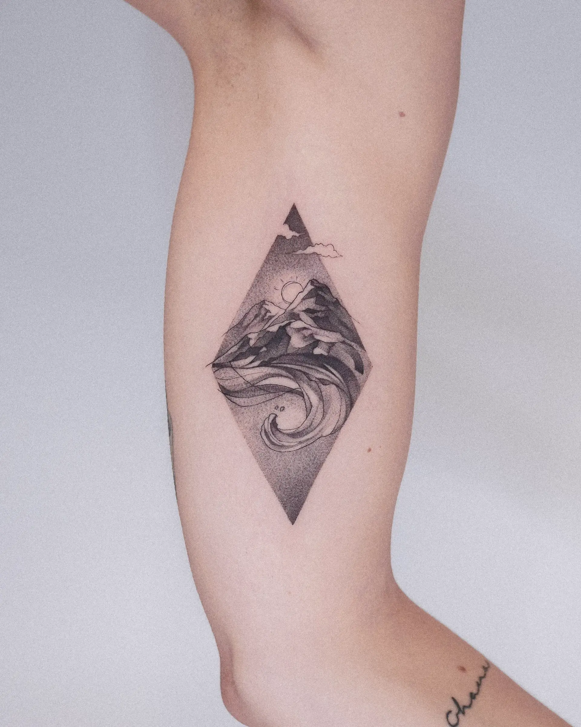 Geometrisches Rauten-Tattoo am Innenarm, frisch — Welle und Berg in Schwarzgrau mit Stippling-Schattierung.