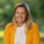 portrait einer frau in gelber jacke laechelt in die kamera