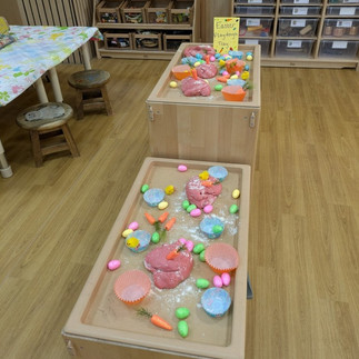 a table covered in playdough with easter theme props carrots/ eggs