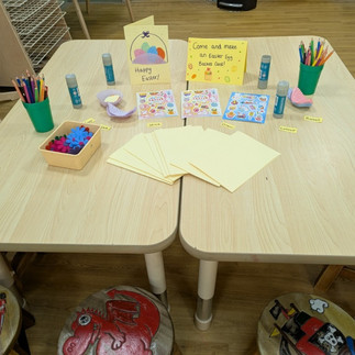A table with yellow paper and pencils for making easter cards