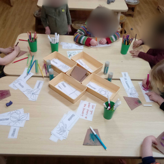 preschoolers sitting at a table drawing spring flowers