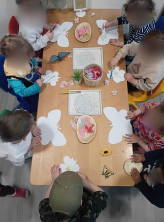 A group of children spreading glue and sticking paper on