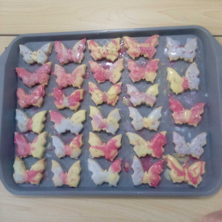 a tray filled with colourful butterfly biscuits
