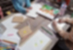 outside table in nursery garden with paper, pens and chalk and children drawing flower pictures