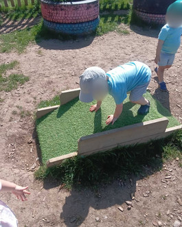 child climbing on frame in nursery garden