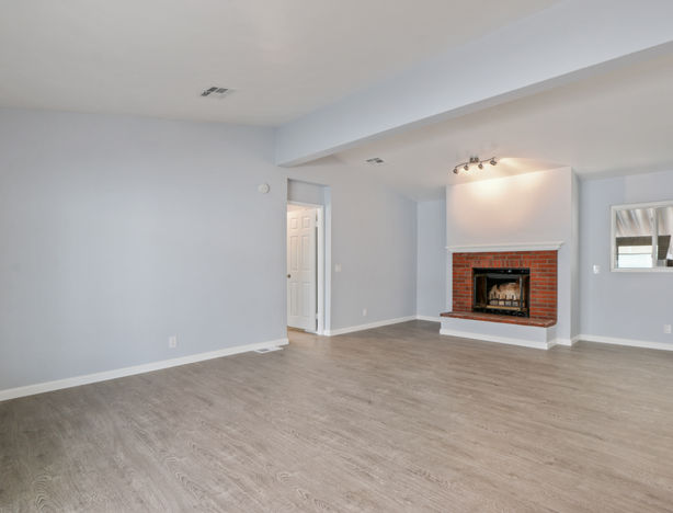 Spacious living room with fireplace and wood-look floors