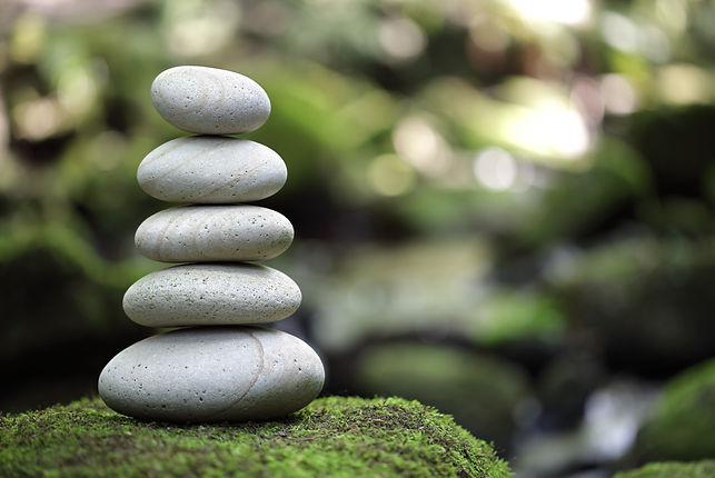 Stack of pebble stones by a stream in a