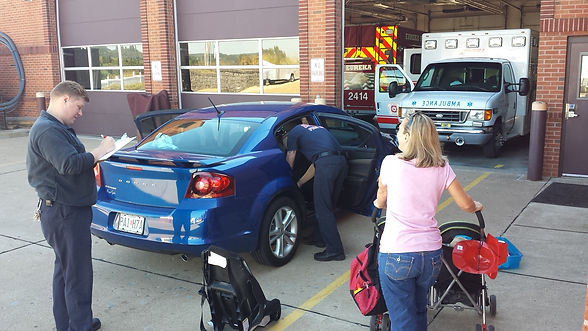 A blue car receiving a safe carseat installation by the firefighters of the Eureka Fire Protection Department