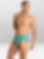 Joven modelo masculino en ropa interior turquesa Gigo, posando sobre fondo blanco.