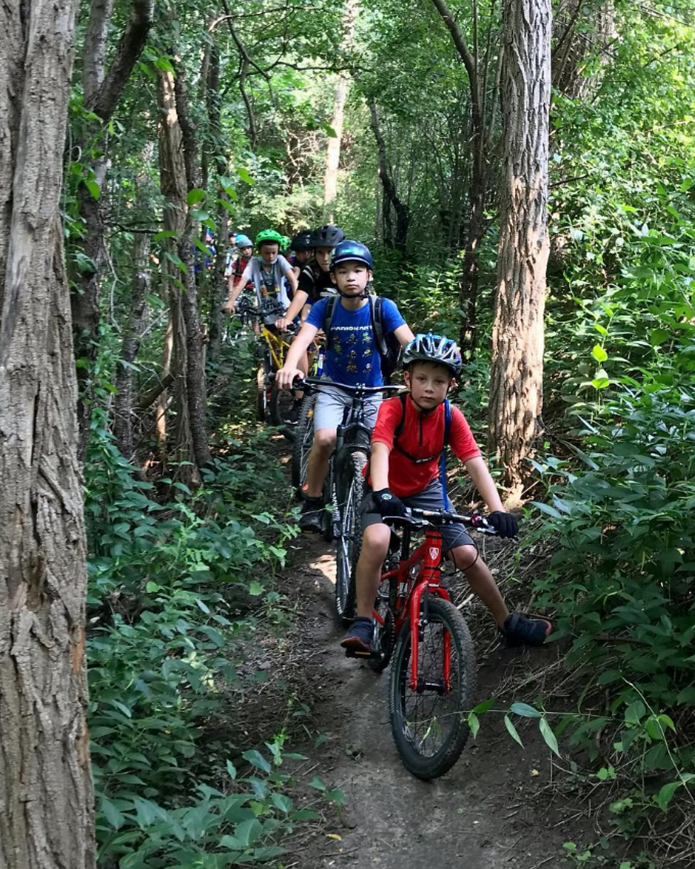 A group of CASMA summer campers biking through lush Toronto nature trails, combining outdoor exploration with active summer camp fun. Cycling at CASMA helps kids stay active, connect with nature, and build confidence through guided outdoor programs in Toronto and North York.