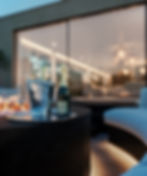 Depth of field view of Aura Westmill fire pit with an ice bucket full of champagne