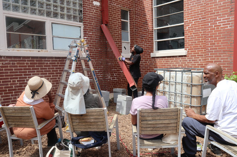 Students watching Garden Manager and Yogi Tenisio Seanima give a rain water collection workshop