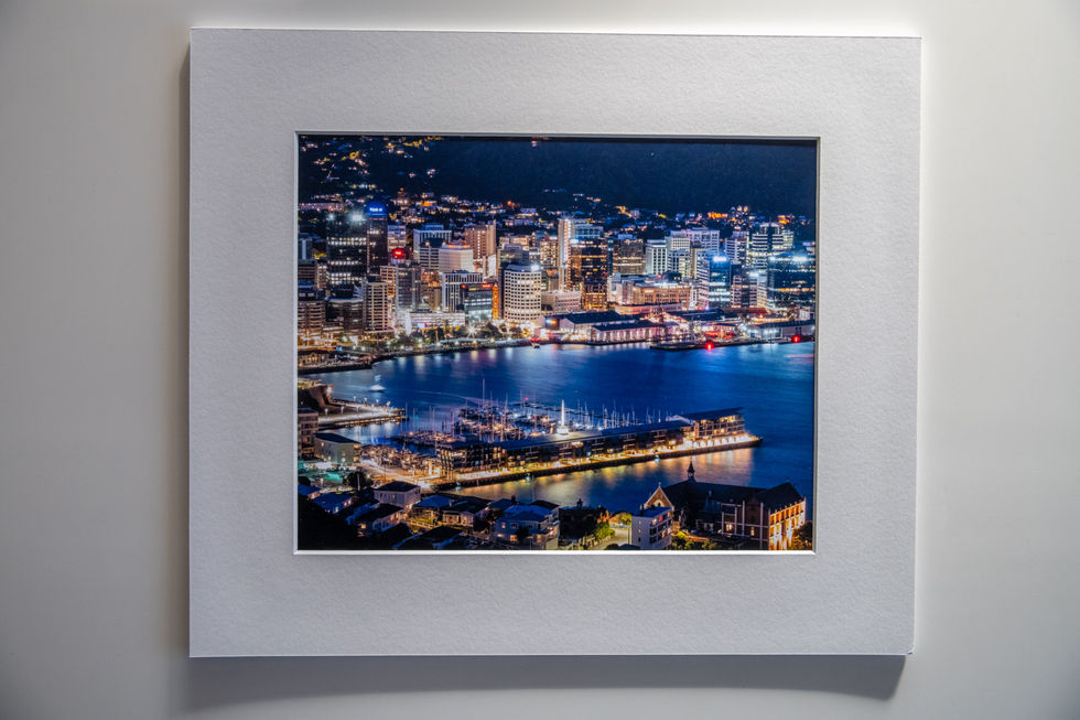 Example framed image of Wellington CBD area and waterfront lit up at night.