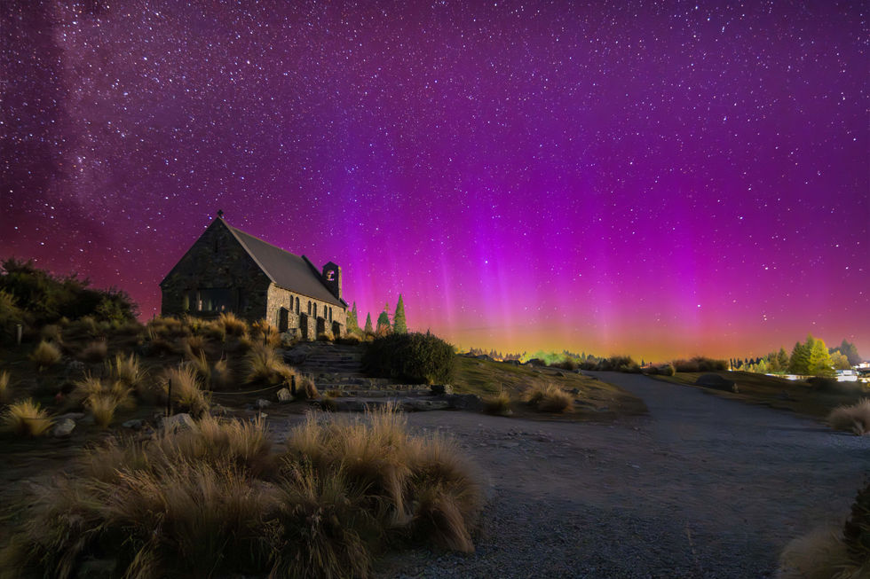 Church of the Good Shepherd with stunning Aurora with brilliant yellow, pinks and purples shining up in shafts of light.
