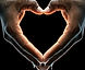 A picture of two hands forming a heart covered in ice, with a warm glow coming from the inside of the hands.
