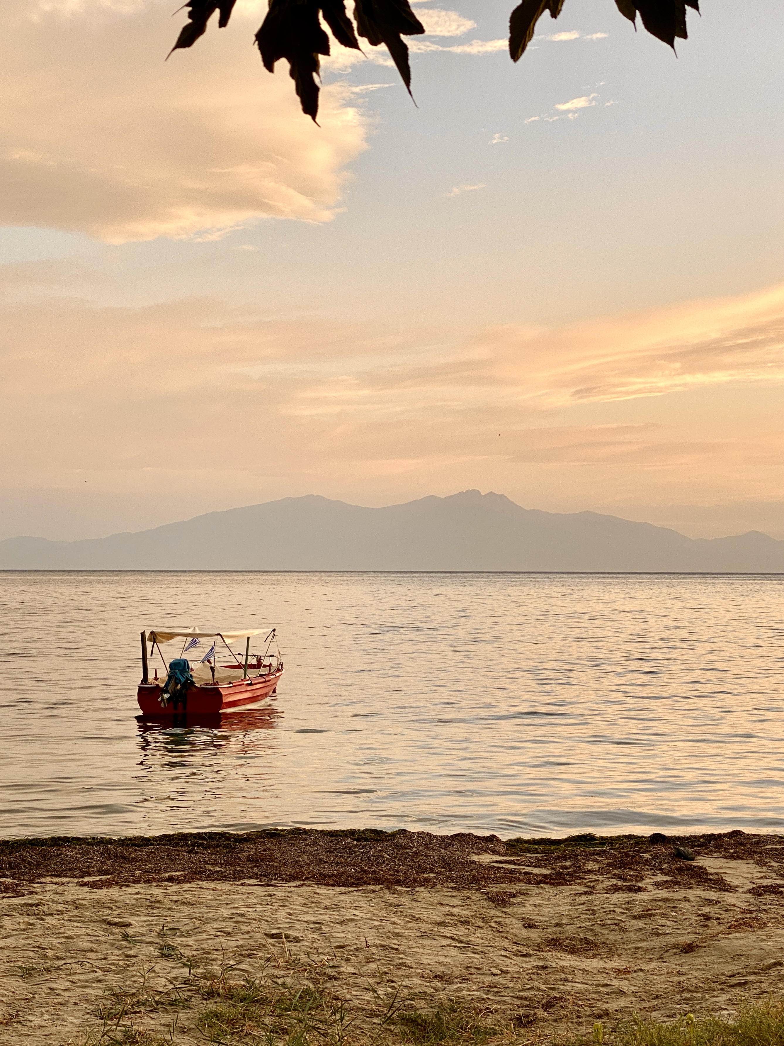The Thermaic Gulf near Epanomi in evening light, a fishing boat on the water, Mount Olympus on the horizon
