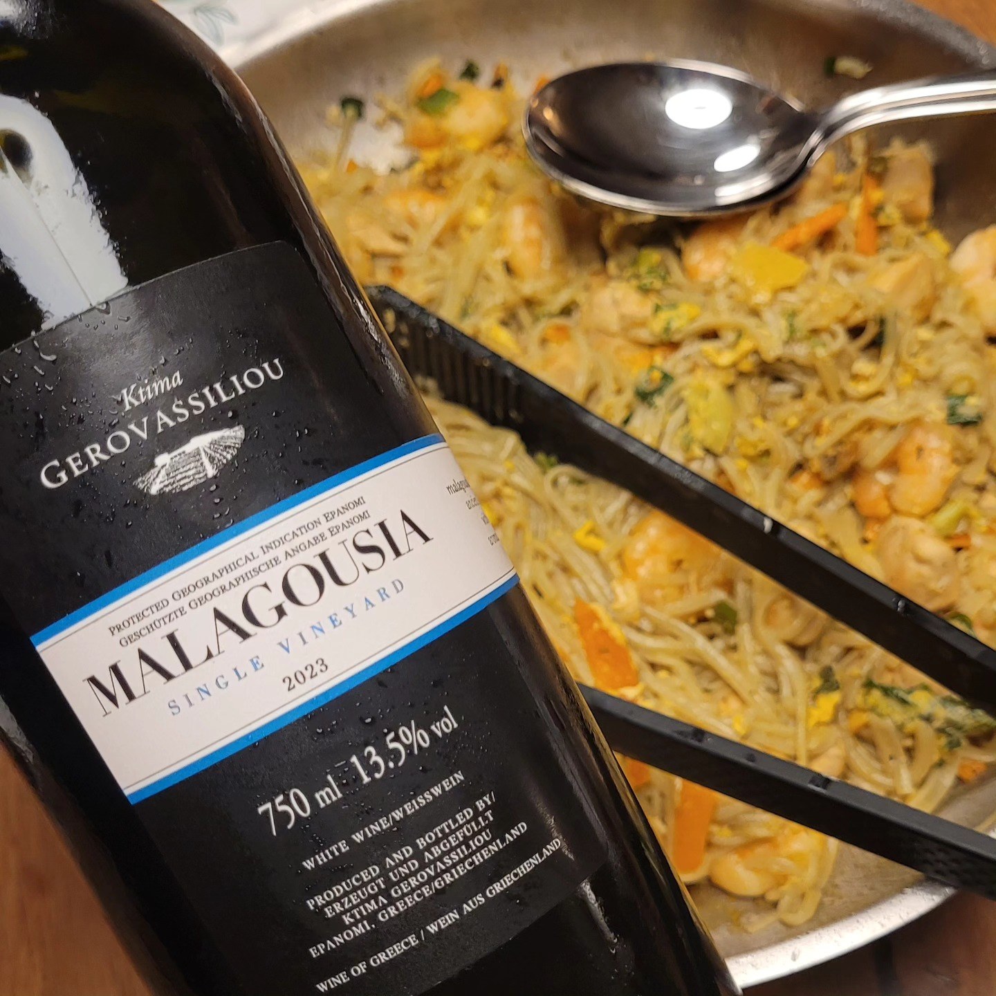 Bottle of Ktima Gerovassiliou Malagousia Single Vineyard 2023 next to a pan of glass noodles with prawns