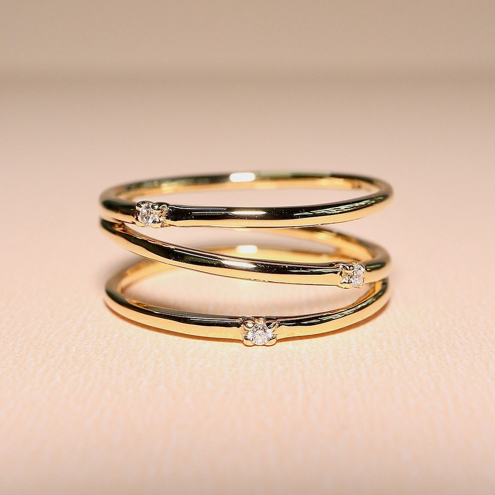 Minimalist three-stone diamond ring with flush-set diamonds on a thin fine gold band.