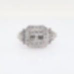 Art Deco statement diamond ring with an illusion cluster, double halo, and baguette accents on a hand.