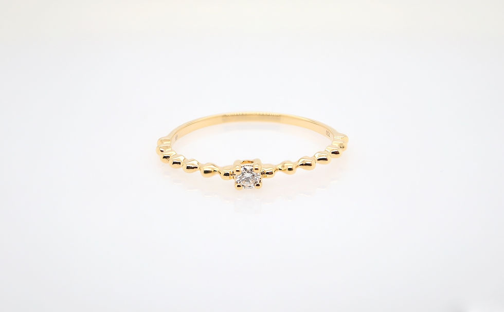 Thumbnail: Dainty diamond ring with a single brilliant stone on a delicate beaded gold stacking band.