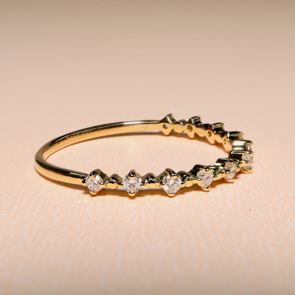 Delicate shared-prong diamond ring with a minimalist half eternity design on a thin gold band.