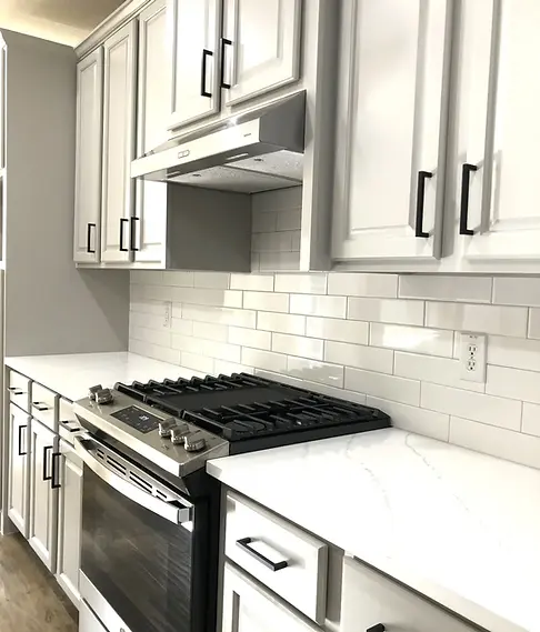 White shaker cabinets, quartz countertops and subway tile backsplash in a rebuilt McKinney kitchen