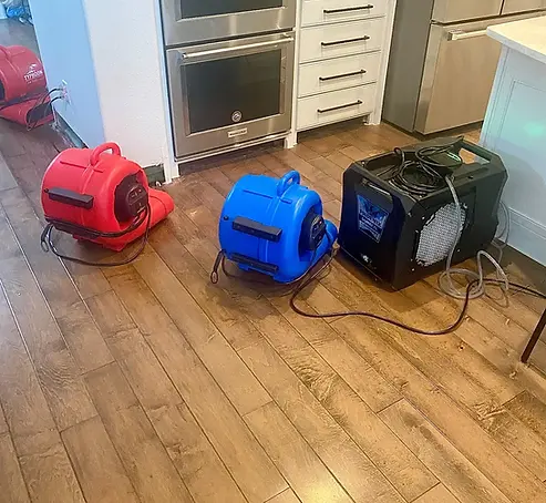 Structural drying equipment positioned on hardwood floors during water damage restoration in McKinney TX