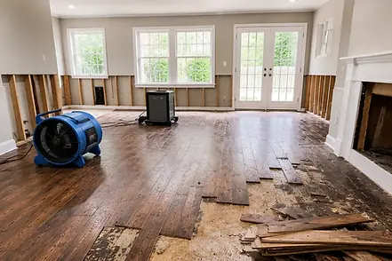 Water-damaged hardwood flooring being removed during residential water damage restoration