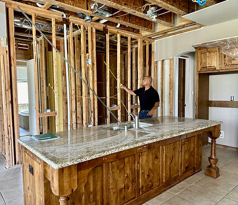 Active kitchen renovation with framing, electrical prep, and island base installed.