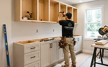 Contractor installing custom kitchen cabinetry and millwork during home reconstruction