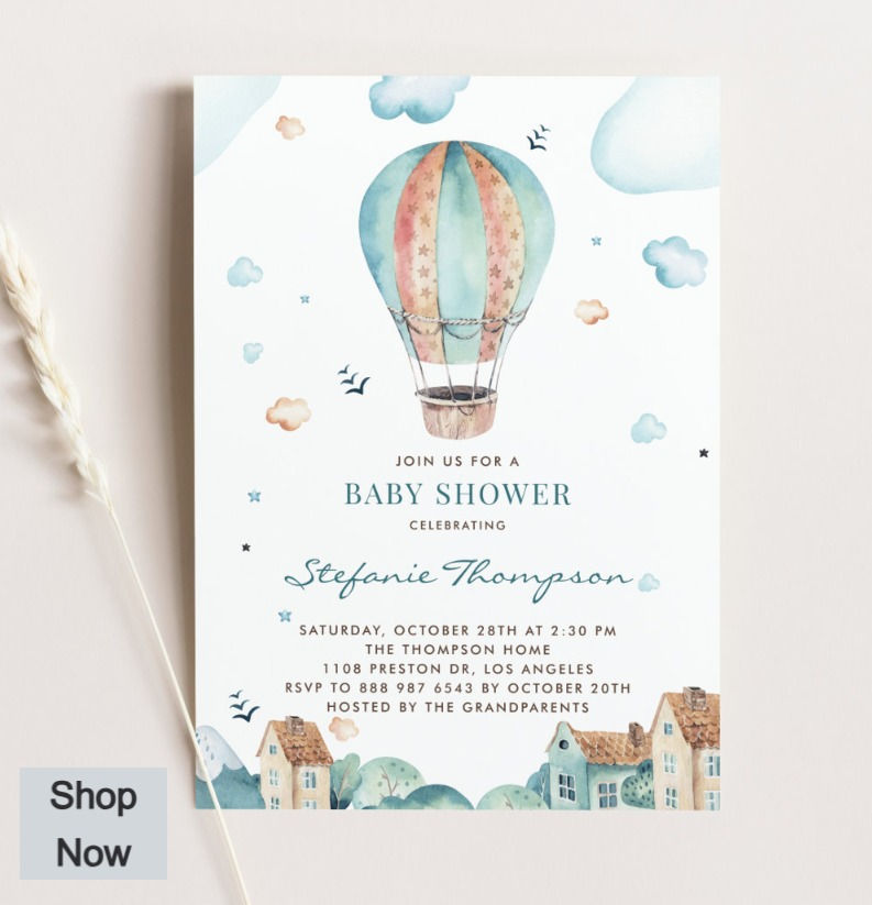 A watercolor picture of a hot air balloon flying over houses on a baby shower invitation