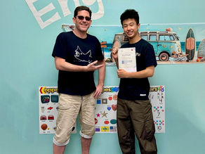Fantastic Englishの生徒が英検1級の合格証書を持ち、講師と一緒に笑顔で写真に写っている