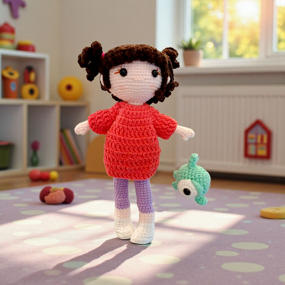 Front view of handmade crochet girl doll with brown hair, red dress, and mini mint-green monster plush, standing on a playmat