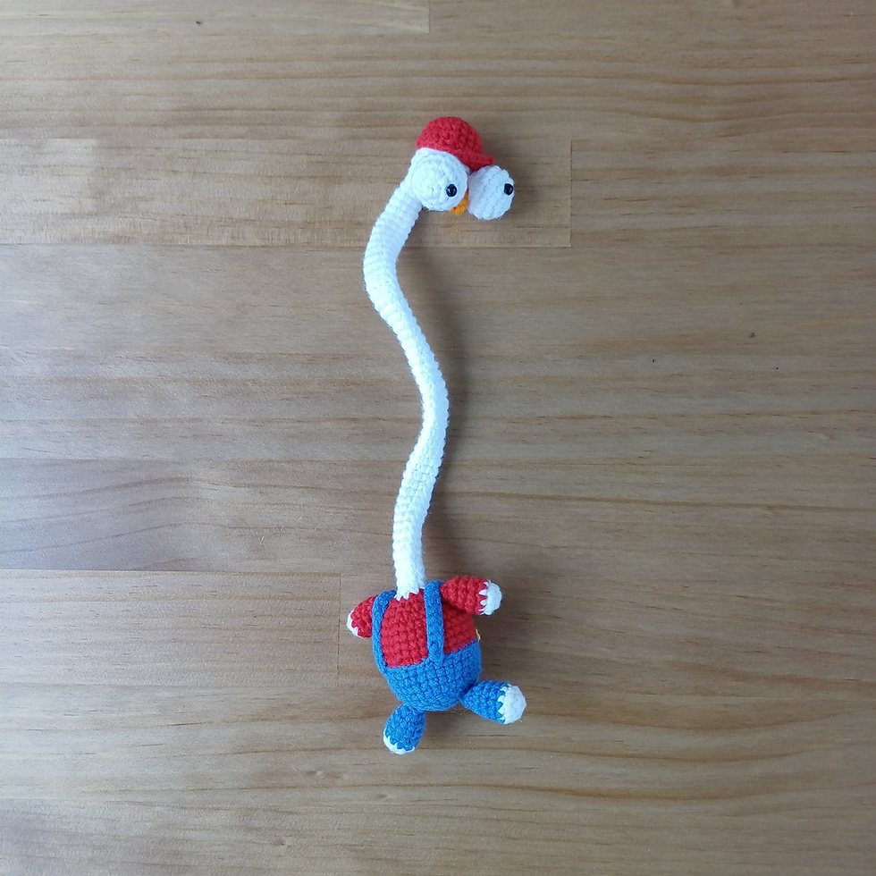 Thumbnail: White crochet bird bag charm wearing a red cap, red shirt and blue overalls.