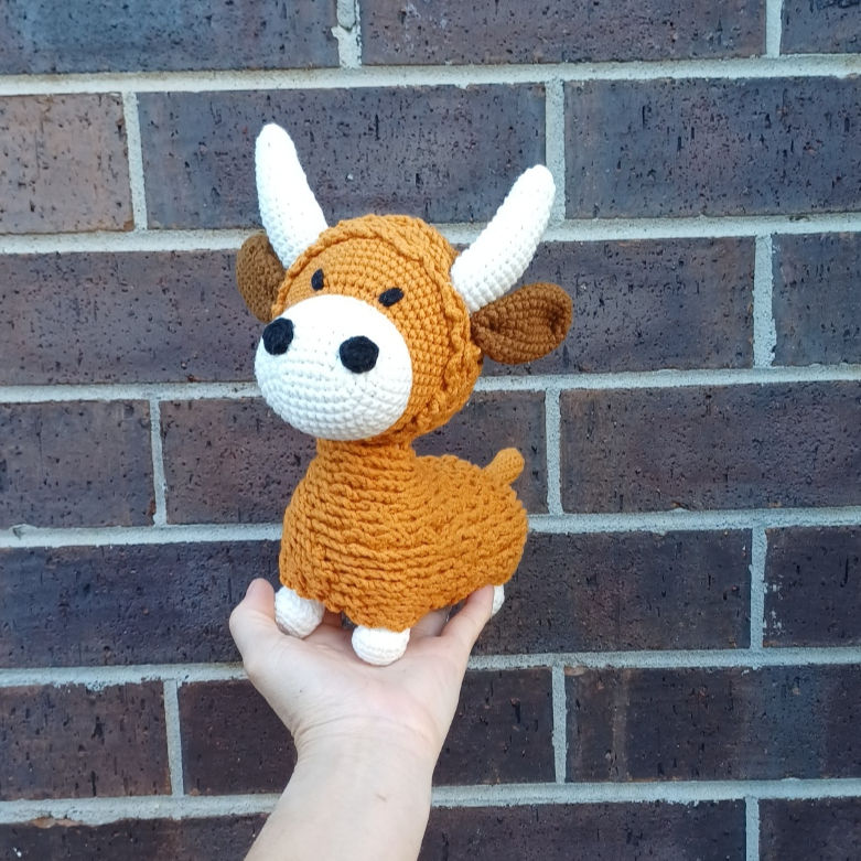 Handmade Highland cow amigurumi plush facing forward showing soft crochet details and gentle expression.