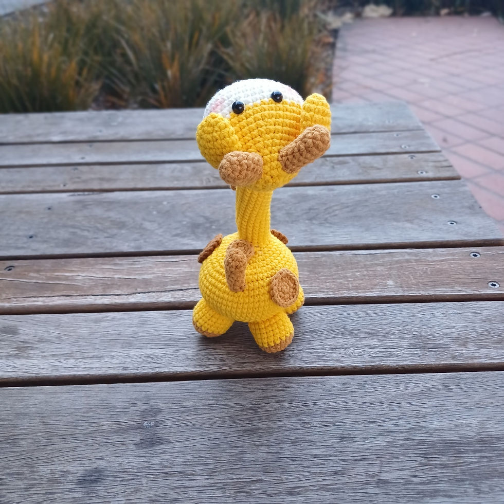 Cute handmade amigurumi giraffe plush with yellow and brown details, 20 cm tall.