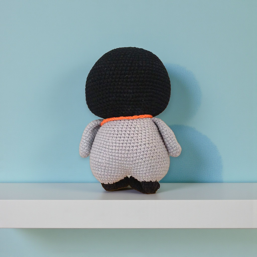 Back view of crochet penguin doll showing smooth black yarn texture and rounded handmade stitching.