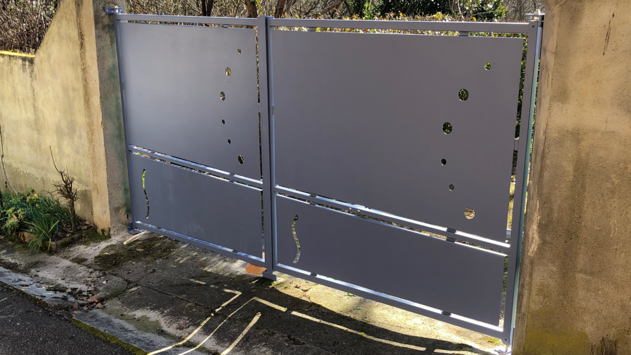 Grandes portes grises Portail entre deux murs en béton, détails de l'extérieur.