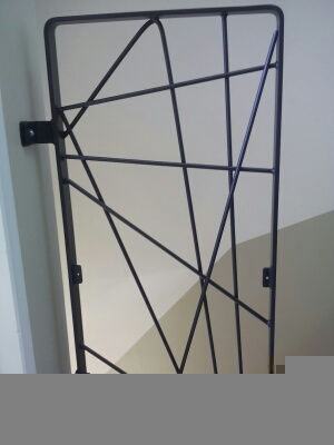 Grille en métal noir contre le mur avec des lignes géométriques. Grille.