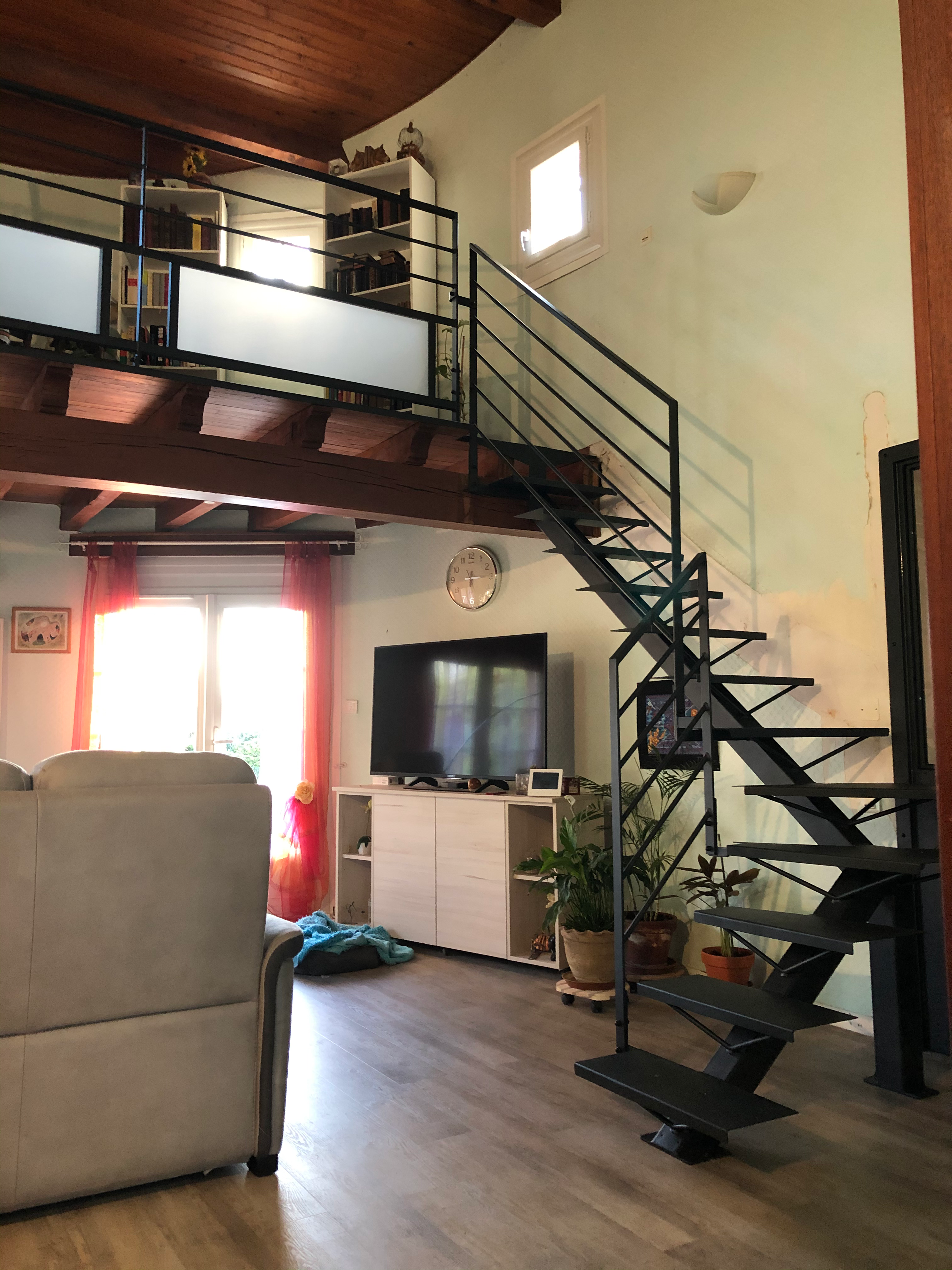 Intérieur avec escalier et rampe et mobilier en bois. Pièce lumineuse.