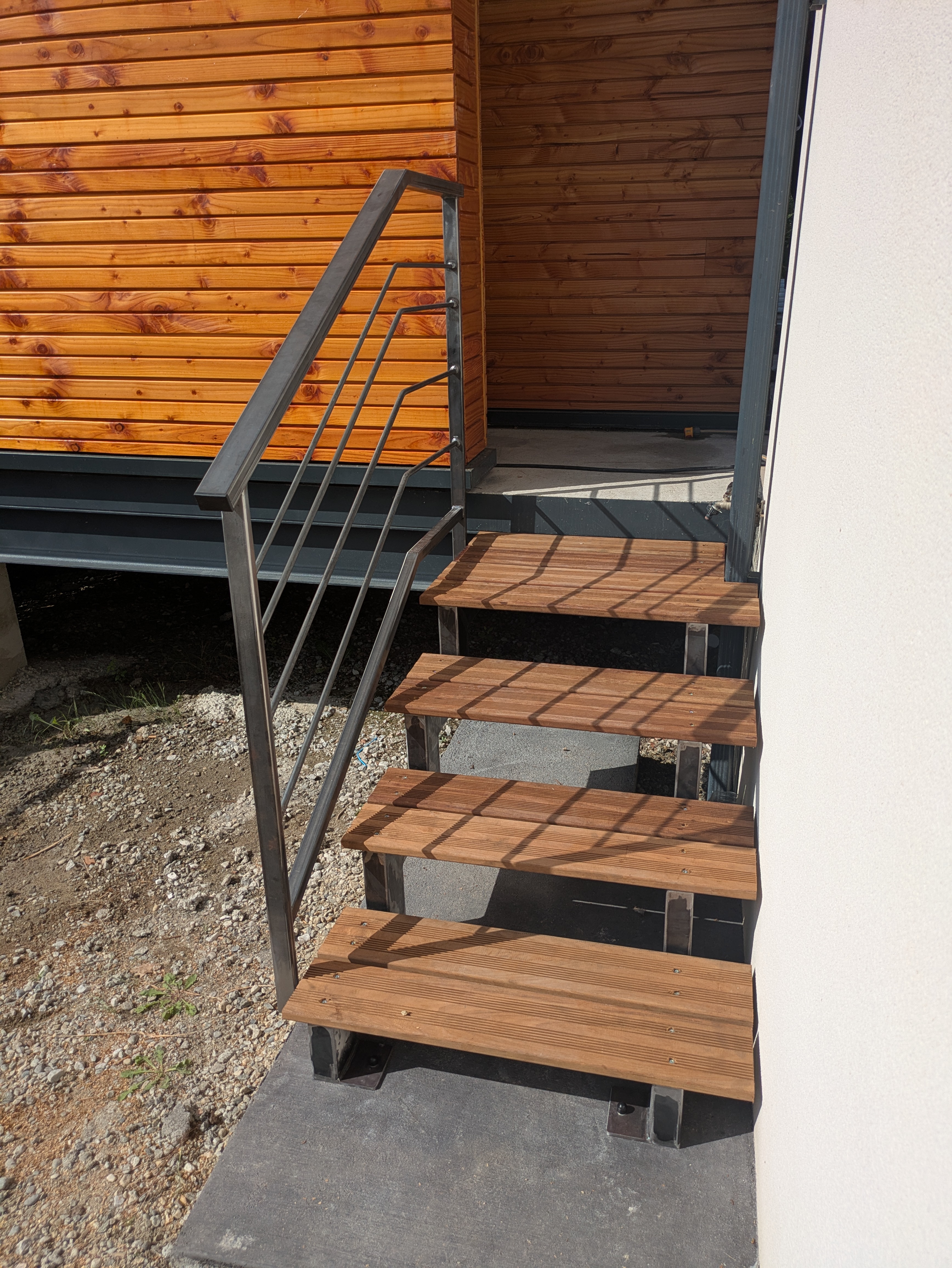 Marches en bois avec garde-corps métallique. Escalier & Rampe. Vue extérieure, jour.