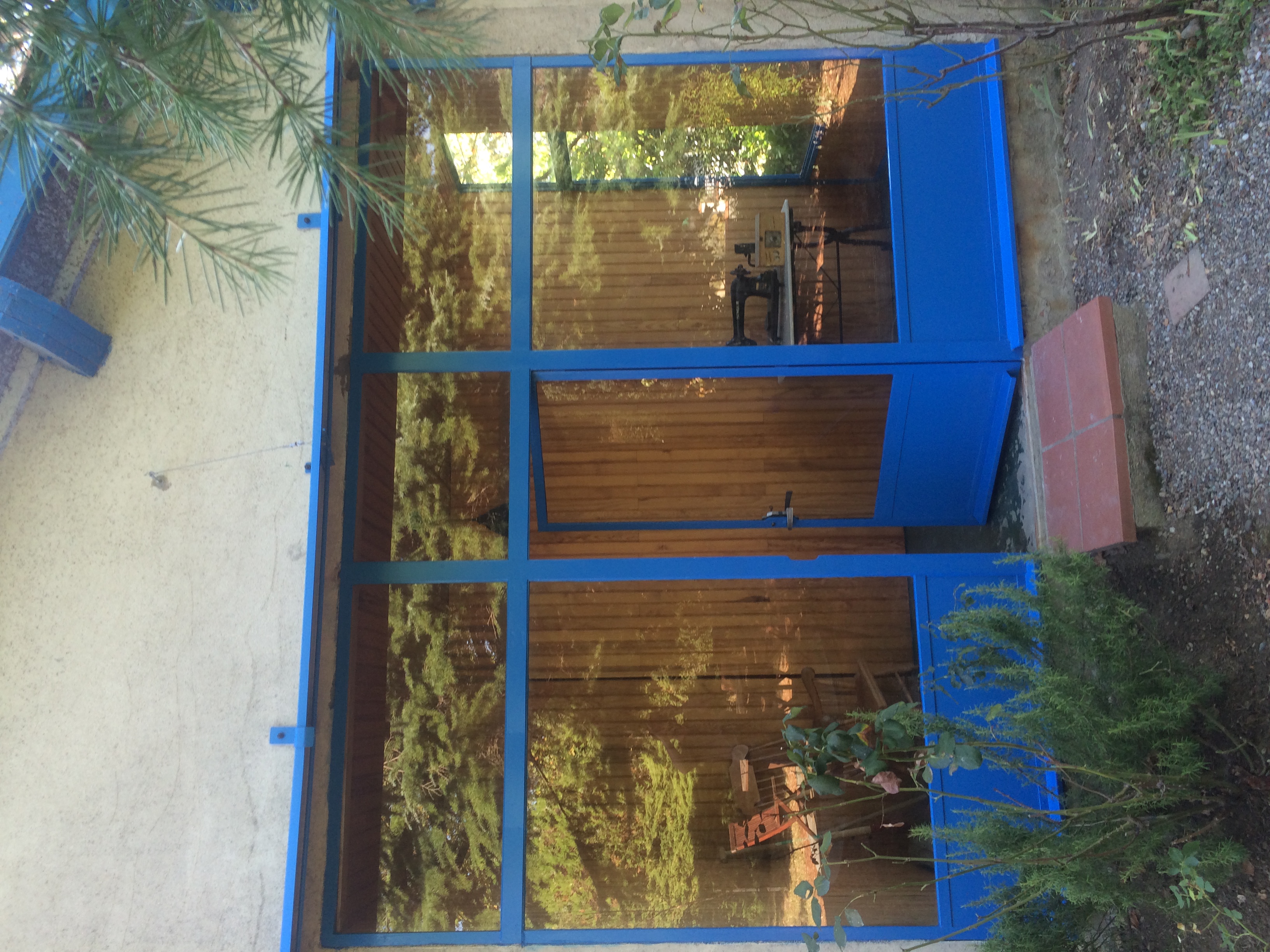 Façade d'un bâtiment bleu avec une porte. Verrière, un bâtiment dans la nature.